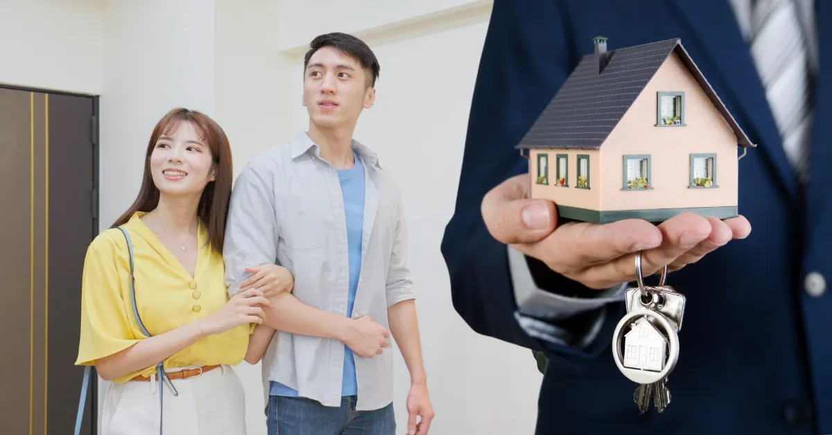 Couple with a real estate agent holding a tiny house
