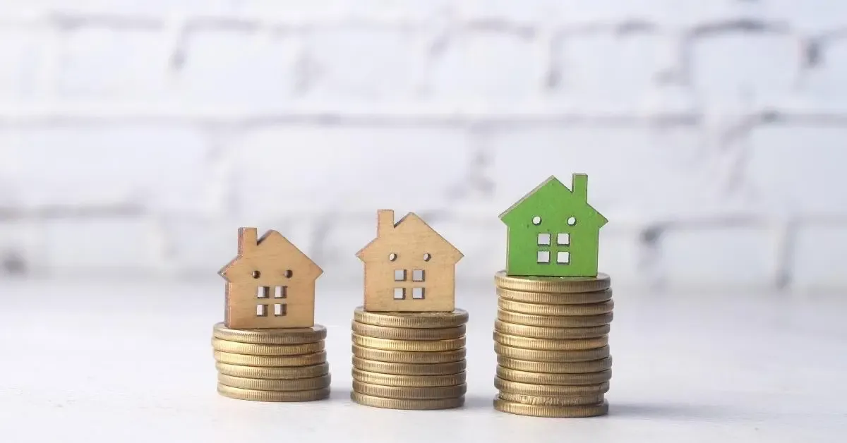 Coins stacked in ascending order with wood houses on top