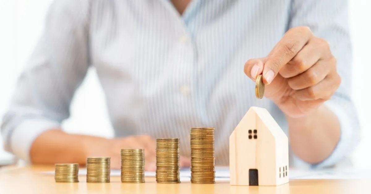 Stacked coins increasing to becoming a small wooden house