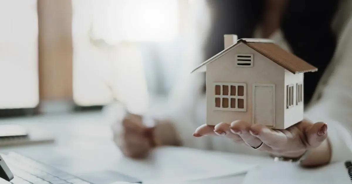 House figurine on top of woman palm