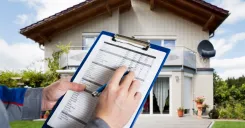 Appraiser in front of house with a clipboard